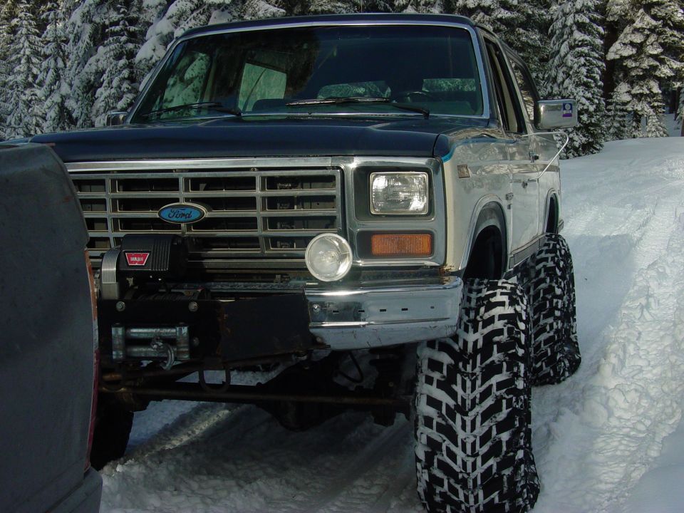 1986 Ford Bronco front with winch and large tires in snow