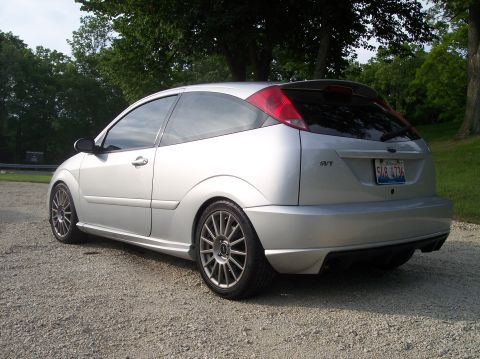 2003 Ford Focus - This silver Ford Focus SVT is shown from the rear quarter angle, parked on a gravel surface with trees in the background.