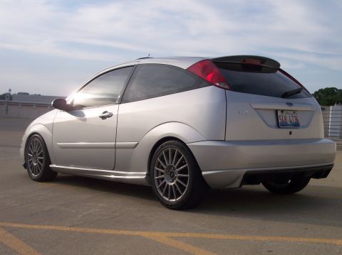 2003 Ford Focus - The rear of a silver Ford Focus SVT hatchback is shown with a spoiler and custom wheels.