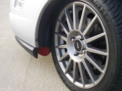 2003 Ford Focus - Close-up of a white car's front fender and wheel, an SVT center cap and aftermarket alloy wheel.