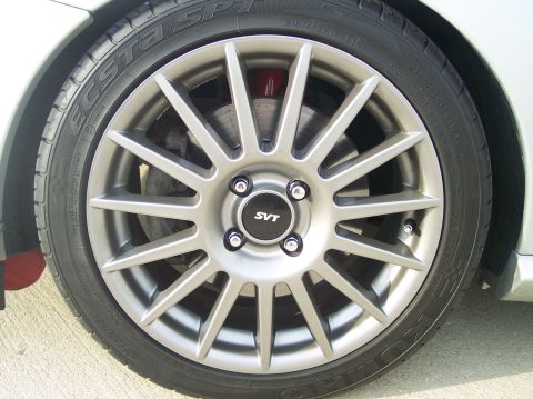 2003 Ford Focus - Vehicle wheel with SVT center cap and visible brake caliper.