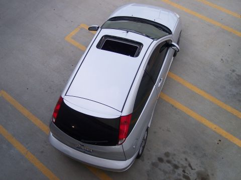 2003 Ford Focus - A silver hatchback is parked in a lot with yellow lines, viewed from a high angle.