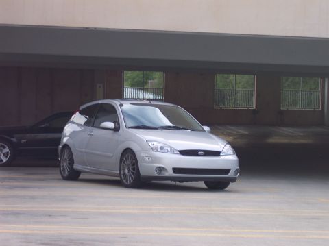 2003 Ford Focus - A silver Ford Focus is parked in a garage, with another car visible behind it.