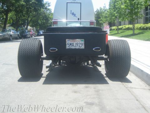 1968 Ford Mustang - A modified hot rod is seen from the rear, oversized tires and a custom body.