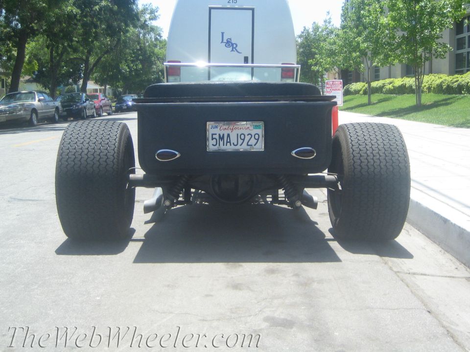 Black hot rod rear view with large tires and California license plate 5MAJ929