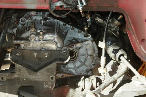 1991 Ford Taurus - Close-up of a transaxle case in a front-wheel-drive engine bay, photographed from below with the axle removed to expose the open output sea…