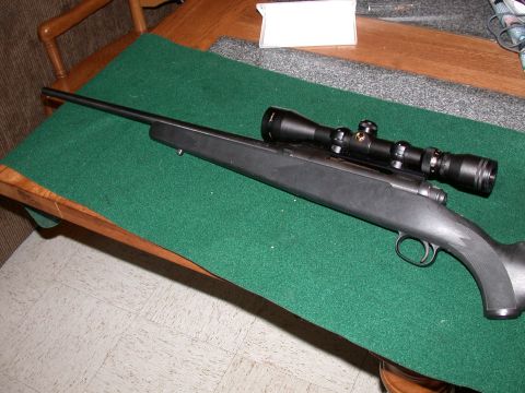 1991 Ford Bronco - A rifle with a scope is displayed on a green felt mat on a wooden table.