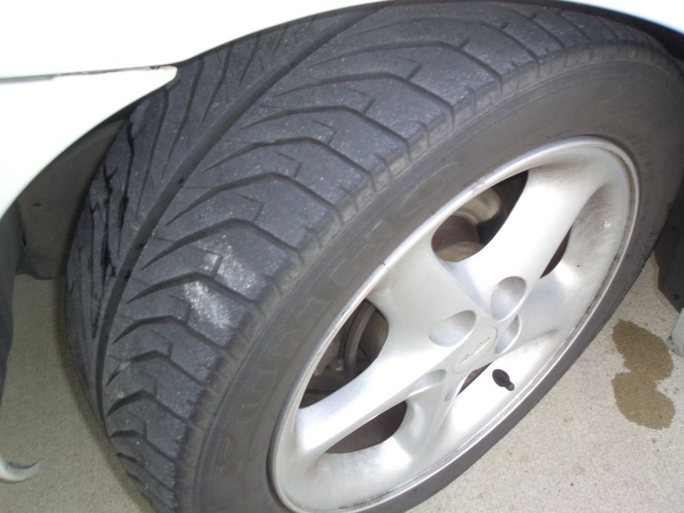 Front alloy wheel and performance tire on a white car