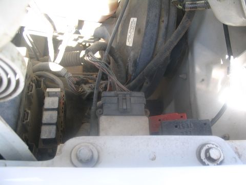 1994 Ford Bronco - Close-up of the fuse box and wiring in a vehicle's engine bay.