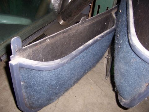 1991 Ford Bronco - Close-up view of blue carpeted door panels with dark trim, likely from an older vehicle.