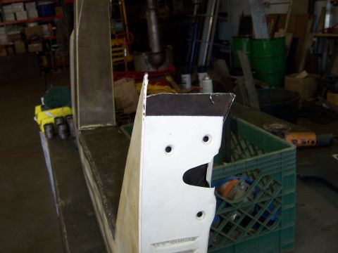 1991 Ford Bronco - A white vehicle body panel with cutouts and holes is shown in a workshop setting.