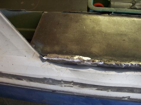 1991 Ford Bronco - Close-up of a vehicle's body panel undergoing repair, with visible welding marks.