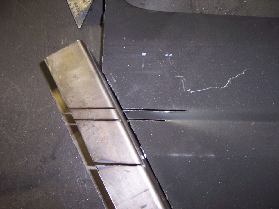 Metal tubing being cut and fitted to a dark vehicle panel