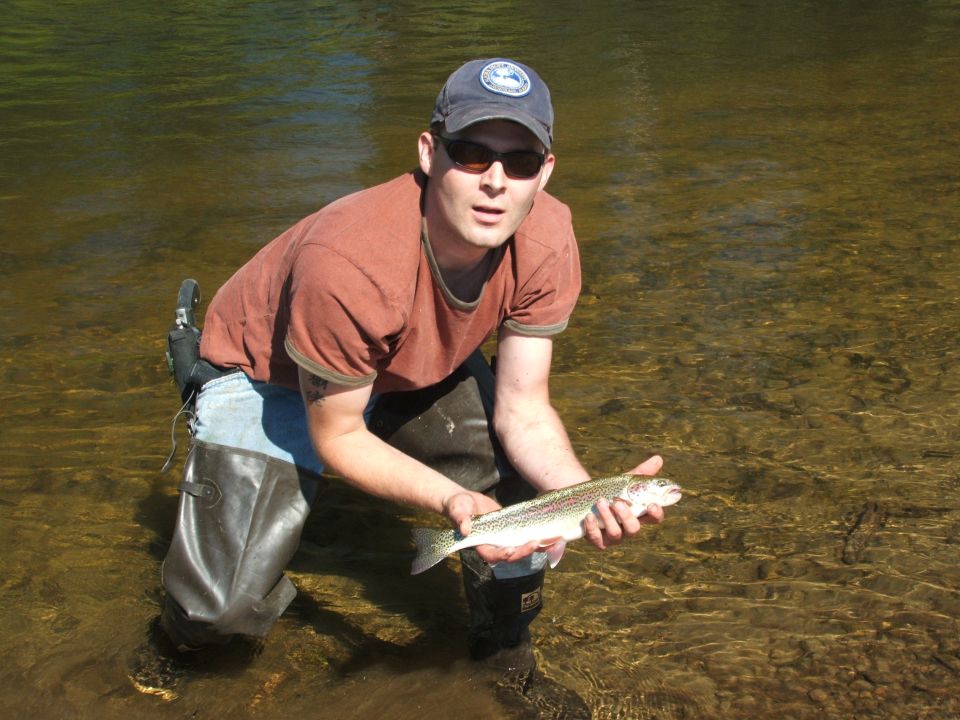 guy in waders holding a trout