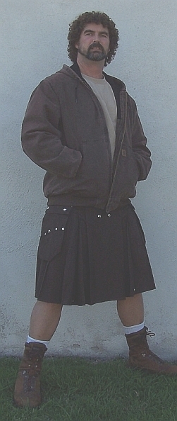 1990 Ford Bronco - A man poses in a kilt and jacket, standing in front of a textured wall with grass at his feet.