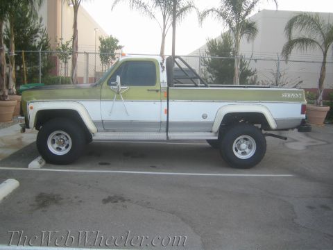 1987 Suzuki Samurai - Side view of a two-tone pickup truck with a roll bar and "SERPENT" badging on the tailgate.