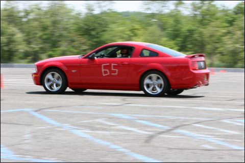 2001 Mercury Grand Marquis - A red Ford Mustang with the number 65 on its door participates in an autocross event.