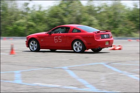 2001 Mercury Grand Marquis - Red Ford Mustang with racing number 65 navigates a course marked by orange cones.