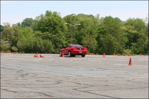 2001 Mercury Grand Marquis - A red sports car navigates a course marked by orange cones on a sunny day.