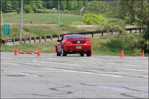 2001 Mercury Grand Marquis - A red Ford Mustang navigates an autocross course marked by orange cones.