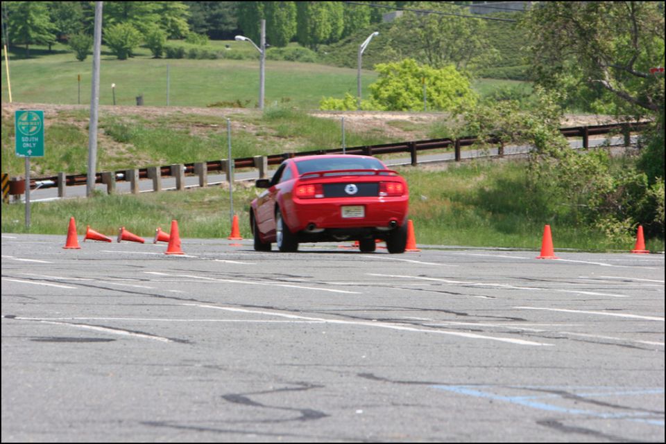 Red Ford Mustang rear view on autocross course