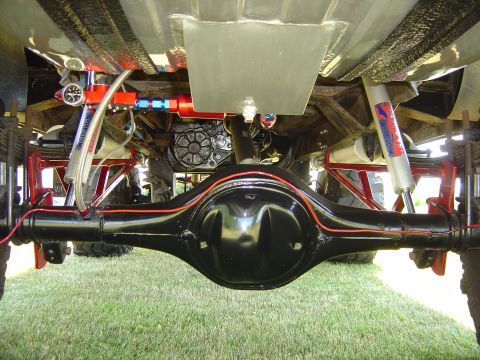 1978 Ford Bronco - The underside of a vehicle reveals its drivetrain and suspension components, with a focus on the rear differential.