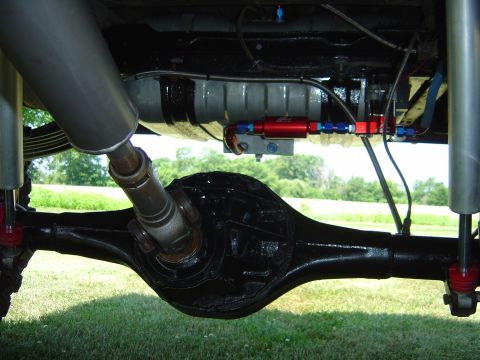 1978 Ford Bronco - Close-up view of the rear axle, exhaust, and fuel lines on a modified vehicle.
