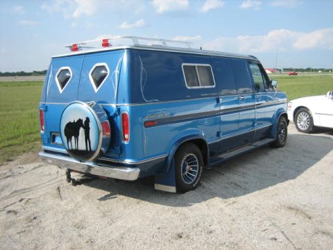 1978 Ford E250 - This 1978 Ford E250 van features a custom blue paint job and a spare tire cover with a horse and rider graphic.
