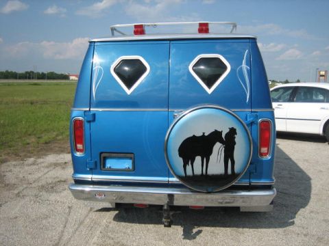 1978 Ford E250 - Rear view of a blue 1978 Ford E250 van a custom spare tire cover with a cowboy and horse graphic.