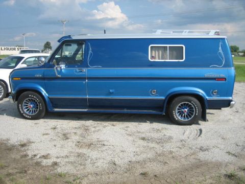 1978 Ford E250 - A blue 1978 Ford E250 van is parked outdoors next to another vehicle.
