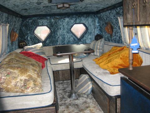 1978 Ford E250 - The interior of a van conversion shows plush seating and decorative diamond windows.