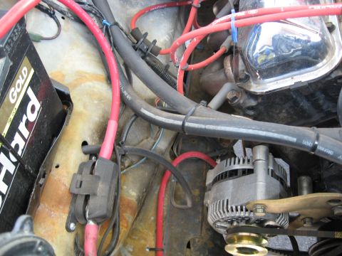 1979 Ford Bronco - The engine bay features a battery, alternator, and various red and black wires connected to engine components.