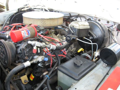 1979 Ford Bronco - Close-up of an engine bay with various components visible, including an air filter and brake booster.