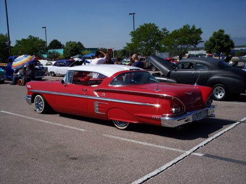 1972 Ford Ranchero - A red and white 1958 coupe with extensive chrome trim is parked at an outdoor event.