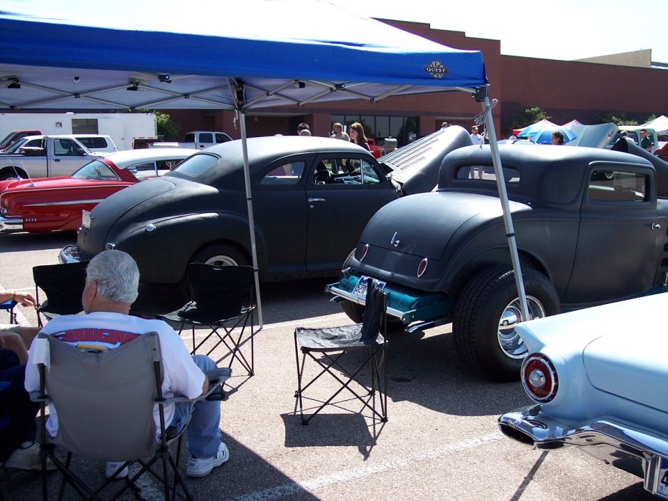 Dark hot rod coupe rear view with wide tires and teal frame
