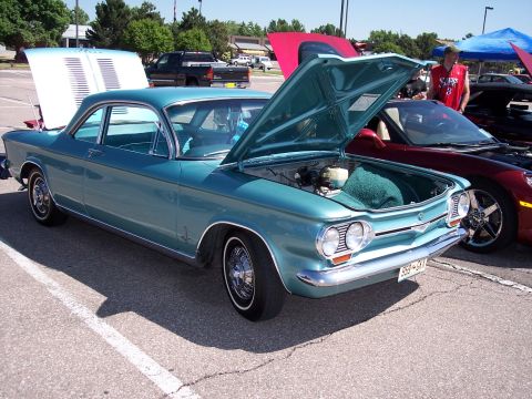 1972 Ford Ranchero - A teal 1965 Chevrolet Corvair coupe is displayed with its hood open at an outdoor car show.