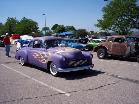 1972 Ford Ranchero - A customized purple hot rod with flame decals is parked in a lot with other vehicles.