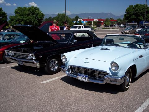 1972 Ford Ranchero - Two vintage convertibles are parked side-by-side in a lot, with people milling around.
