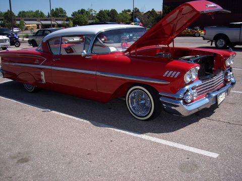 1972 Ford Ranchero - This two-tone red and white coupe features wire wheels and its hood is open, revealing the engine bay.
