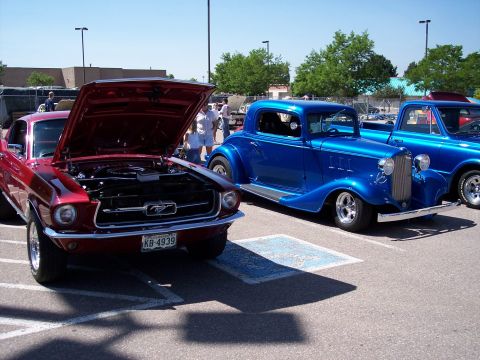1972 Ford Ranchero - Two classic American cars, a red Mustang and a blue coupe, displayed at an outdoor event.