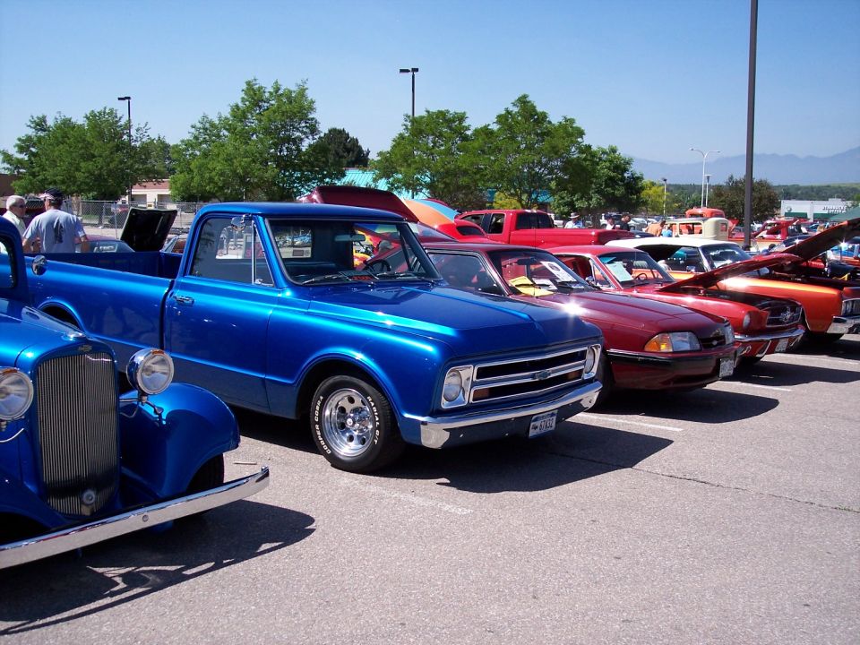 Blue pickup truck parked in a lot with other cars. License plate visible
