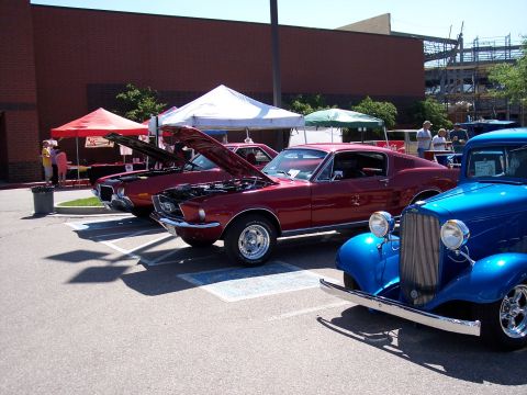 1972 Ford Ranchero - A trio of classic cars, including a red 1967 Ford Mustang and a blue hot rod, are displayed at an outdoor event.