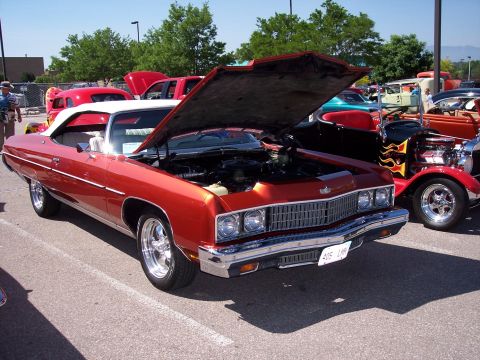 1972 Ford Ranchero - Orange convertible parked at an outdoor event, hood raised to reveal the engine bay.