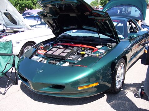 1972 Ford Ranchero - Front view of a green 1998 Pontiac Firebird with its hood open, parked next to other vehicles.