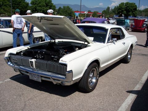 1972 Ford Ranchero - A white 1968 Mercury Cougar is displayed with its hood open, revealing the engine bay.