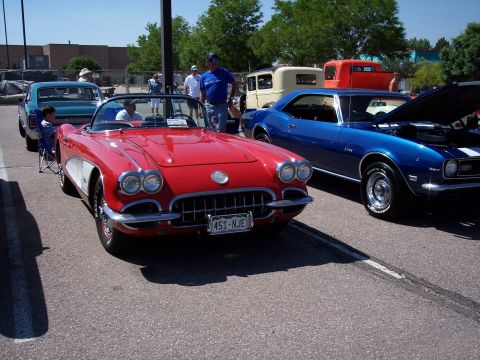 1972 Ford Ranchero - Two classic cars, a red convertible and a blue coupe, are parked side-by-side at an outdoor event.