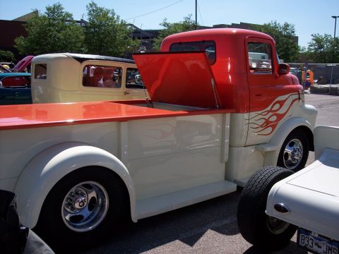 1972 Ford Ranchero - A custom pickup truck with a two-tone paint job and flame graphics is parked next to another vehicle.