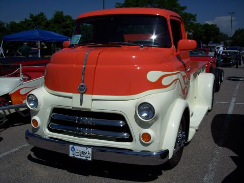 1972 Ford Ranchero - A classic pickup truck with a distinctive two-tone paint job and flame graphics is parked outdoors.