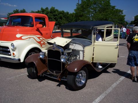 1972 Ford Ranchero - A custom 1930s Ford Model A hot rod is displayed next to a vintage truck with flame graphics.
