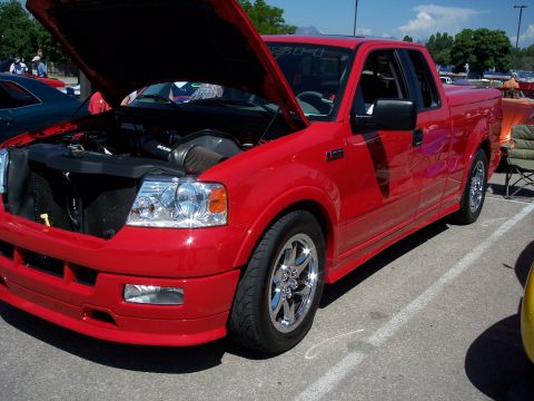 1972 Ford Ranchero - A red pickup truck is parked with its hood open, revealing the engine compartment.